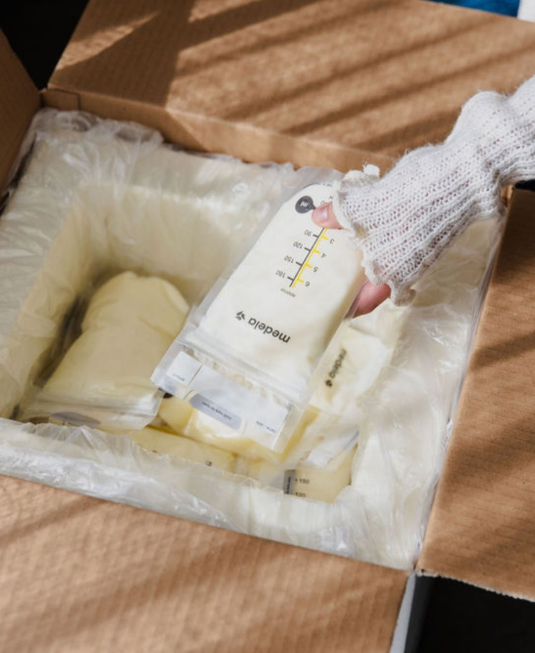 Sachet de lait maternel congelé posé à côté d'un bijou souvenir Prunelle terminé